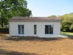 Façade maison en finition gratté et encadrements en gris